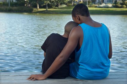 A boy with his brother on a dock by a lake